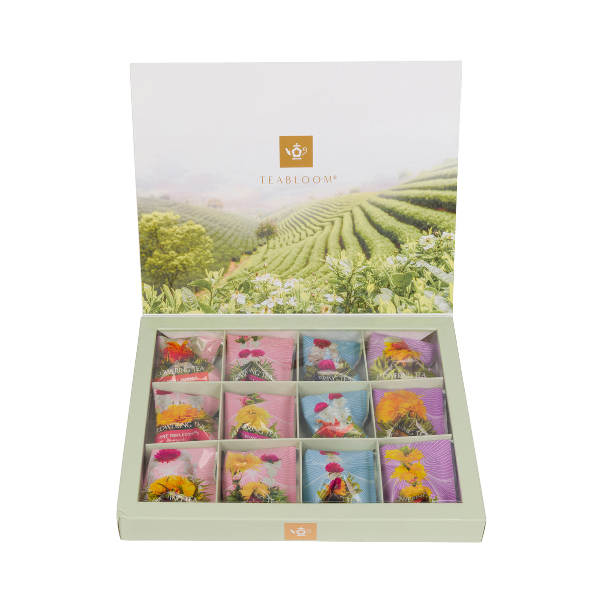 An open rectangular tea gift box with a light sage green base, displaying 12 individually wrapped tea bags arranged in a grid. The tea bags feature colorful floral designs in pink, orange, yellow, and blue.
