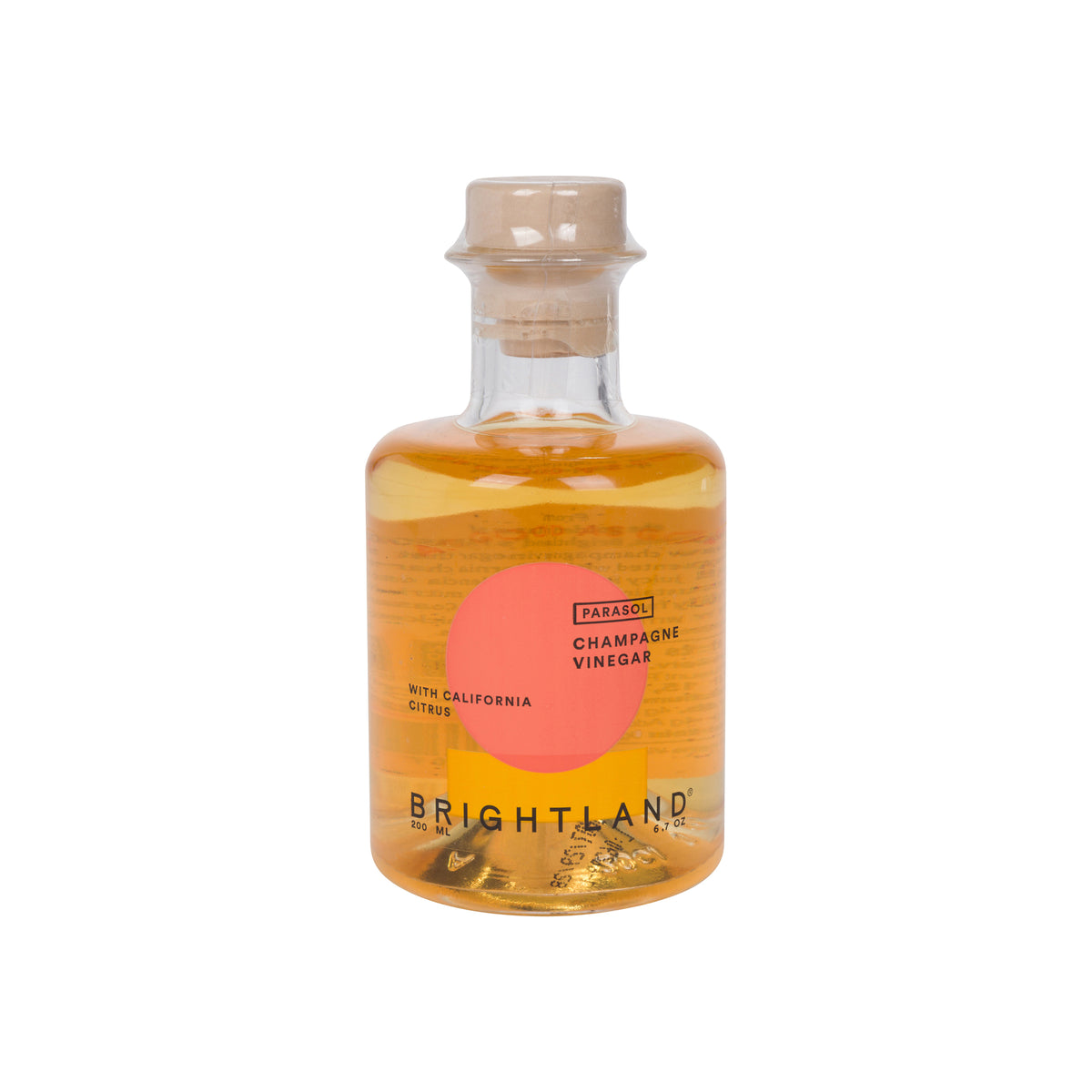 Brightland Patio 48% Champagne Vinegar in a clear glass bottle with a cork stopper, featuring a label with an orange circle and yellow block on a white background.