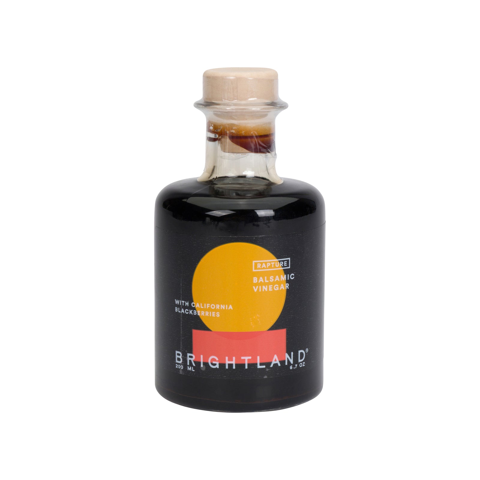 Brightland California Blackberry Balsamic Vinegar in a clear glass bottle with a black label, featuring a yellow and orange sun graphic, and a light wood cork stopper, on a white background.