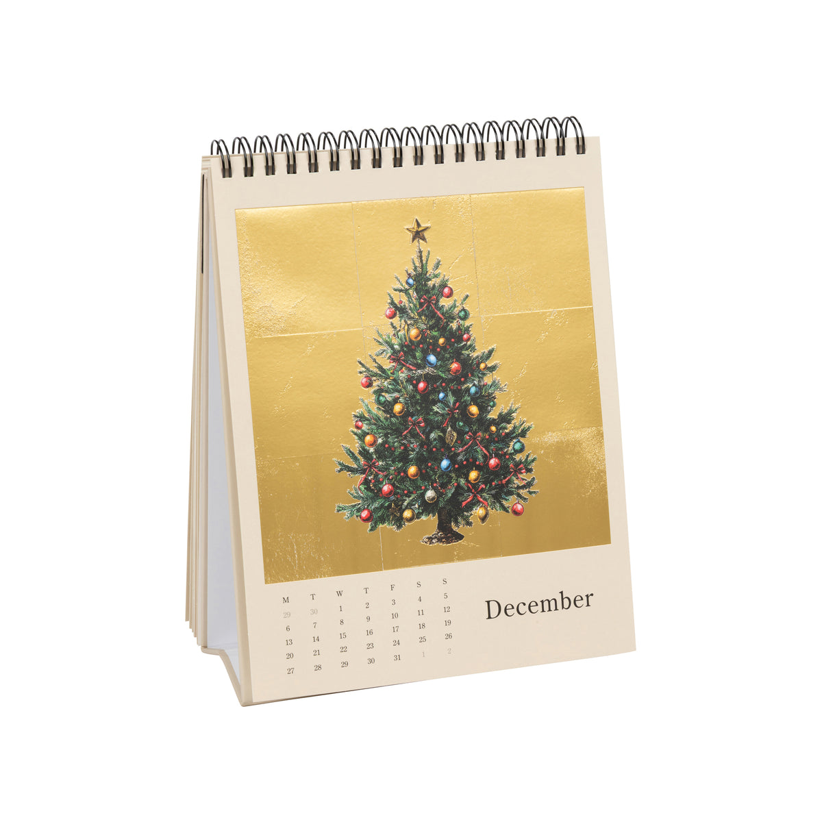 A spiral-bound December desk calendar with a cream-colored page featuring a gold-toned square insert of a decorated Christmas tree and the word 'December' at the bottom.