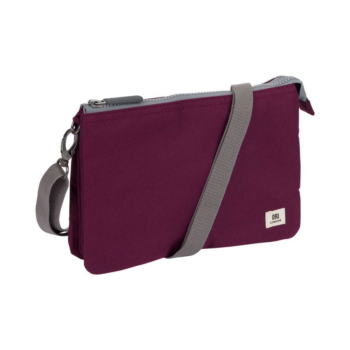A plum purple nylon crossbody pouch bag with a gray adjustable strap and a small white brand label on the bottom right corner, shown on a plain white background.