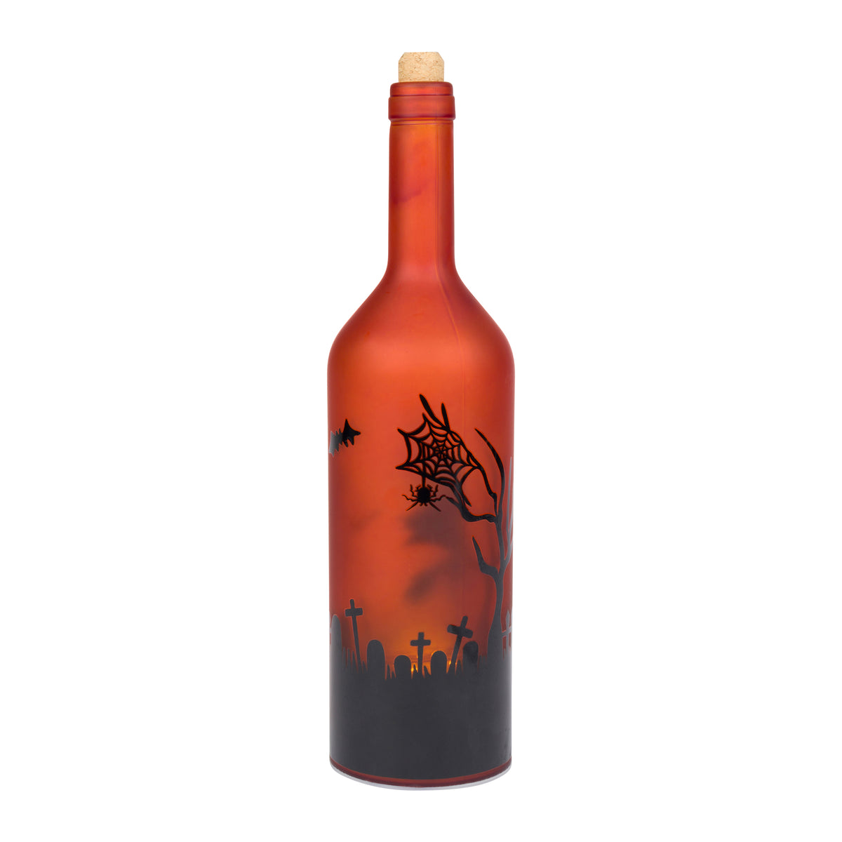 A Halloween-themed glass bottle with a cork stopper, featuring a printed design of a spooky graveyard, tombstones, a bare tree, a spider, and a spiderweb against an orange and red gradient background.