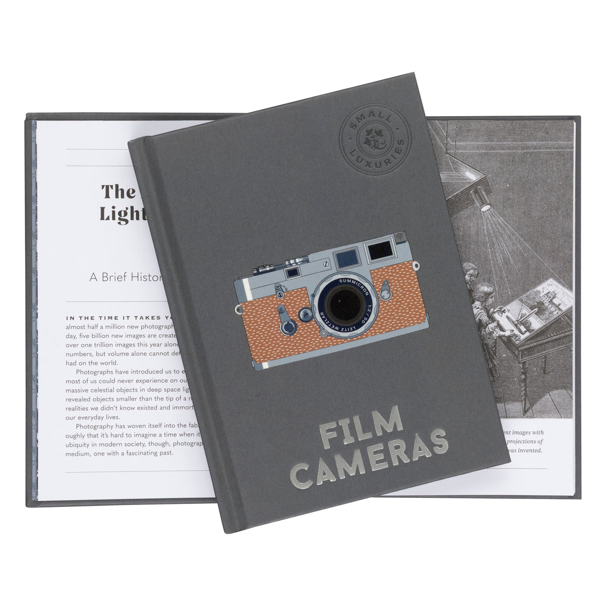 A dark gray hardcover book titled 'Film Cameras' with a vintage camera illustration on the cover, displayed over an open printed booklet on a white background.