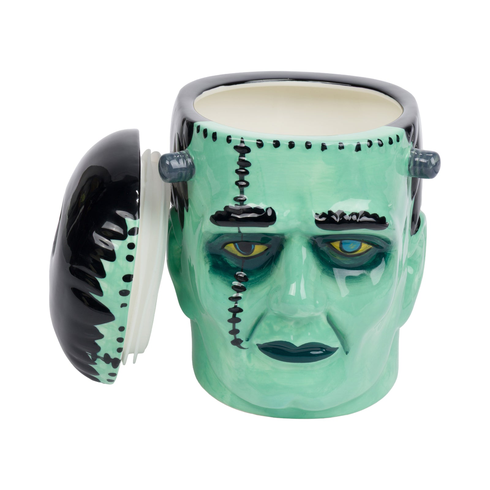 A ceramic Frankenstein's monster head cookie jar with a glossy mint green face, black hair, and stitched details, set against a plain white background.