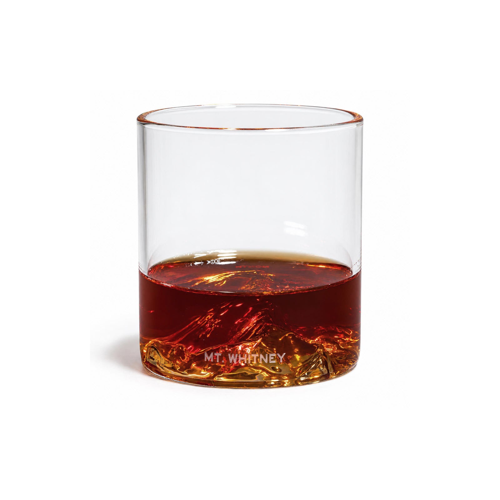 A set of four clear whiskey glasses with mountain-shaped bases, shown with their black retail box on a white background. One glass is placed in front of the box, and the brand label 'NORTH DRINKWARE' is visible on the packaging.