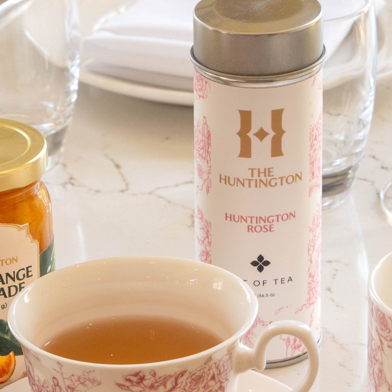 A canister of Huntington Rose tea with a label featuring a rose garden motif and the text 'THE HUNTINGTON ART OF TEA'.