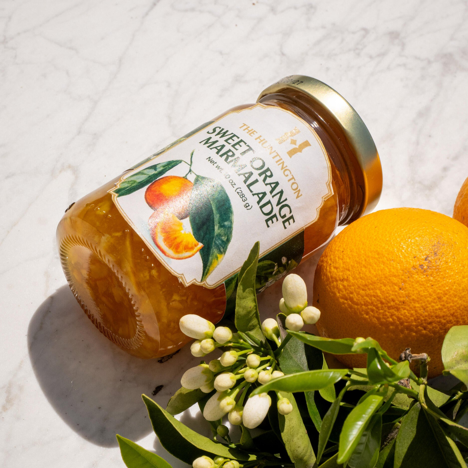 A jar of Huntington Sweet Orange Marmalade with a label featuring an illustration of oranges and leaves.