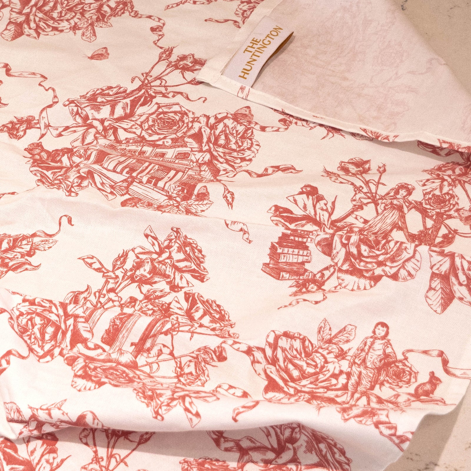 This delightful cotton tea towel features our exclusive Rose Garden toile print. Originally, the French design style of 'Toile de Jouy' prints featured intricate, repeating patterns of scenes or vignettes depicting pastoral or historical themes. Look closely at our toile, and you will notice recognizable Huntington details such as our Tempietto and Faux Bois Rose Arch