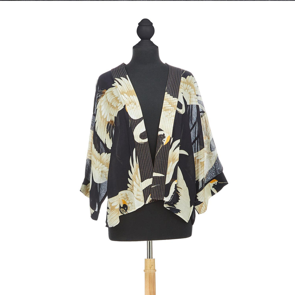 This short kimono features an elegant heron print on a black background. This loose-fitting kimono-style jacket has 3/4-length sleeves, an open front, and a lightly embroidered lapel. Wear this kimono over a dress or pair it with jeans and a long-sleeved T-shirt. One size. (USA 6–16). 50% modal,50% viscose.