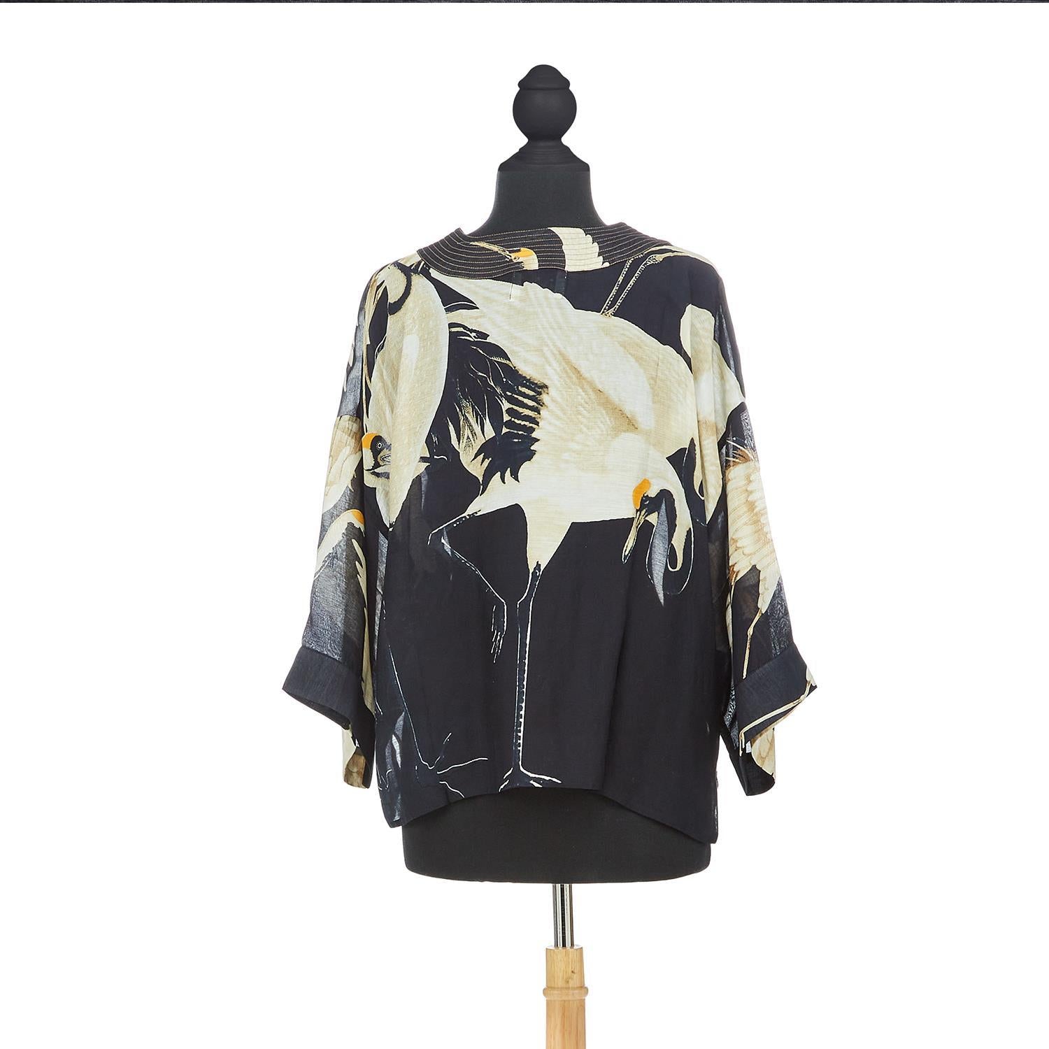 This short kimono features an elegant heron print on a black background. This loose-fitting kimono-style jacket has 3/4-length sleeves, an open front, and a lightly embroidered lapel. Wear this kimono over a dress or pair it with jeans and a long-sleeved T-shirt. One size. (USA 6–16). 50% modal,50% viscose.
