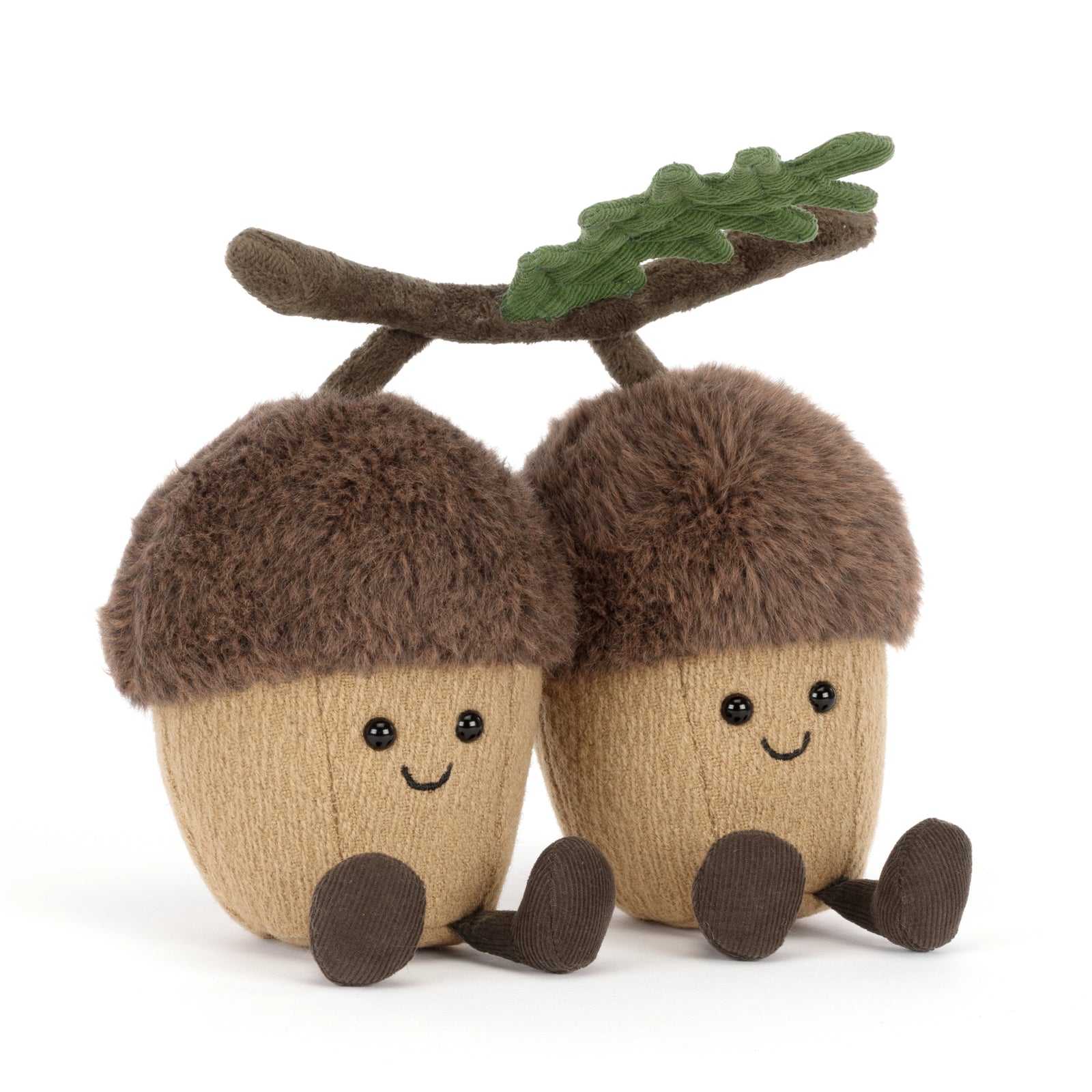 Two plush Jellycat Ort & Tum acorns with faces and a branch on a white background