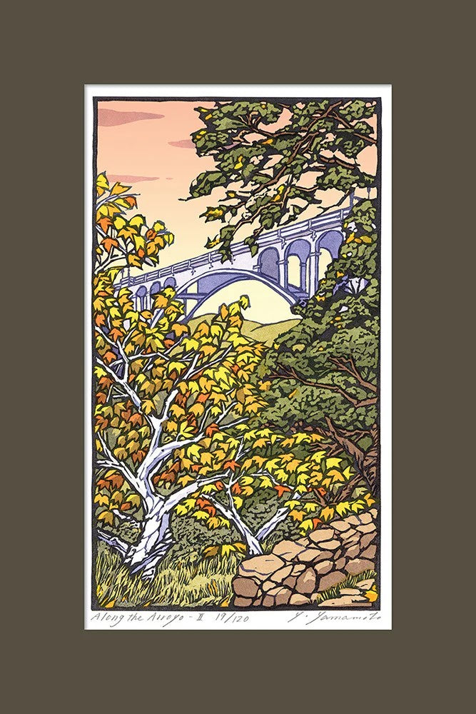 This stunning woodblock print was created by artist Yoshiko Yamamoto. Here, she depicts the picturesque Arroyo Seco with its billowing sycamore trees and majestic oaks form the basis of this delightful scene, with the iconic Colorado Bridge pictured through the branches. Limited edition of 120.  Size: 12" x 18".