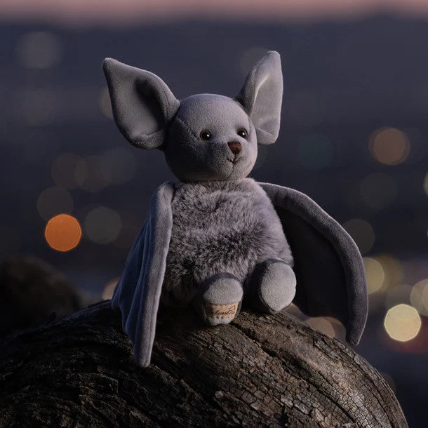 A plush toy resembling a gray bat with soft wings, designed for cuddling.