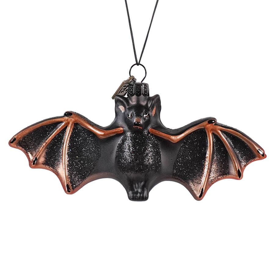 With wings wide open, this beautiful bat is ready to swoop into your Halloween decor with a flair that's both spooky and stylish. The bat, cast in deep black with a subtle shimmer, exudes an eerie elegance. Glass ornament with hand-finished details. Dimensions: 5" x 2".