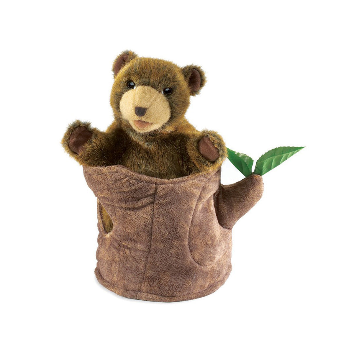 A plush bear hand puppet with brown and tan fur sits inside a brown tree stump puppet, with a green leaf protruding from the side, on a white background.