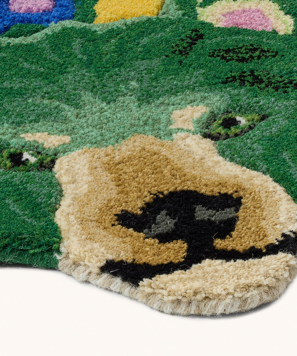 Close-up of a textured rug with a bear design on a green background