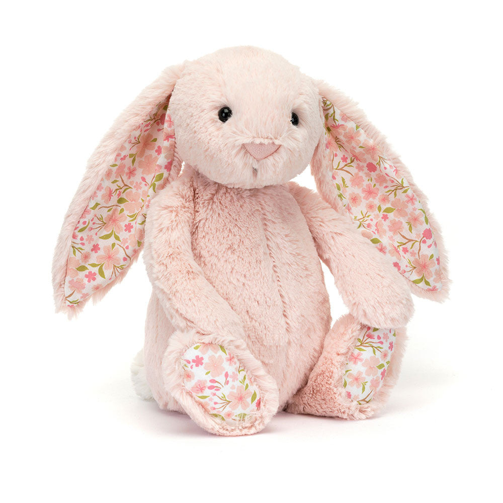 Blossom Blush Bunny has been wandering among the Sakura and collected some of the blooms. In iconic blush-pink Bashful fur with a cream bobtail, Blossom Blush Bunny has soft cotton floral ears and feet printed with an original Jellycat design of pink flowers and green leaves.