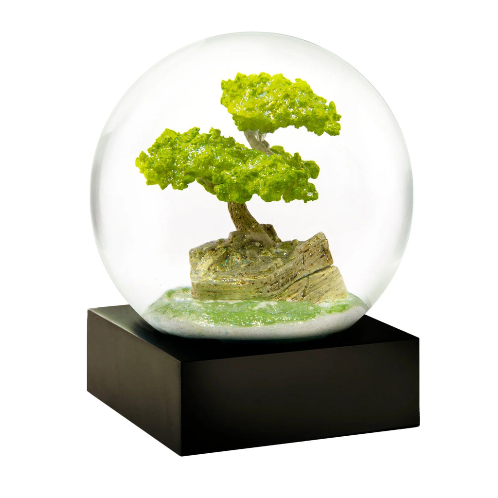 This Bonsai snow globe is a welcome tool for quiet contemplation. A lone tree grows in humble repose, shaped by the weather at its sea-side perch. A symbol and reflection of the world in which it lives, none could be more perfect. Glass snow globe Piano black wood base Packaged in a presentation gift box Size: 3" x 5".