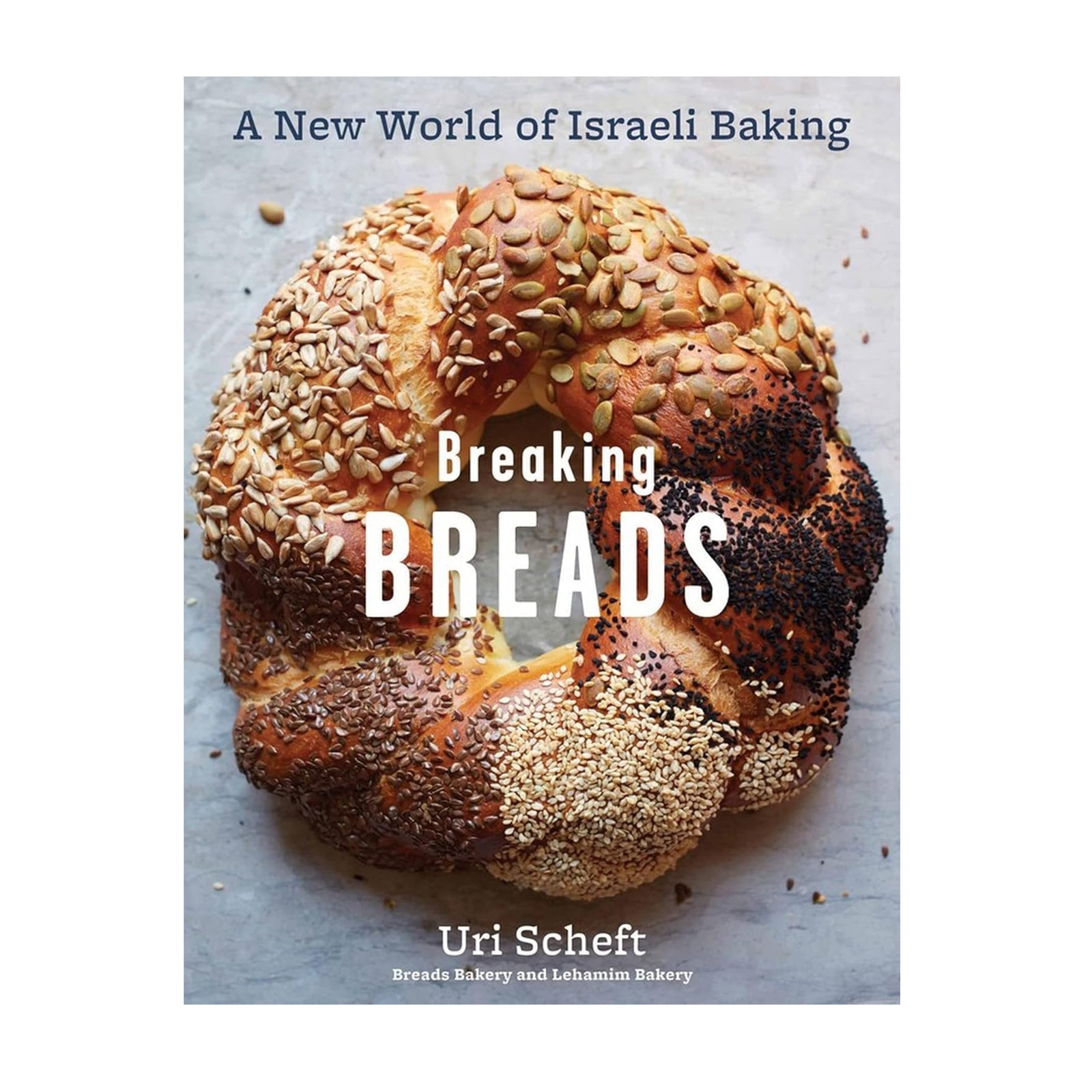 Book cover of 'Breaking Breads' with a loaf of bread featuring various seeds on a light background.