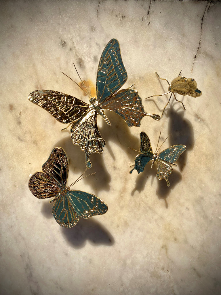 These delightful butterfly figurines are made from a metal alloy with a gold finish. Add a group to a shelf for a natural yet opulent display, or position under a glass bell jar for an on-trend entomology style piece. Large 4" x 3.5" x 2" Medium 2.5" x 2" x 1" Small open: 2" x 2" 1 1" Small closed 3" x 1" x 1".