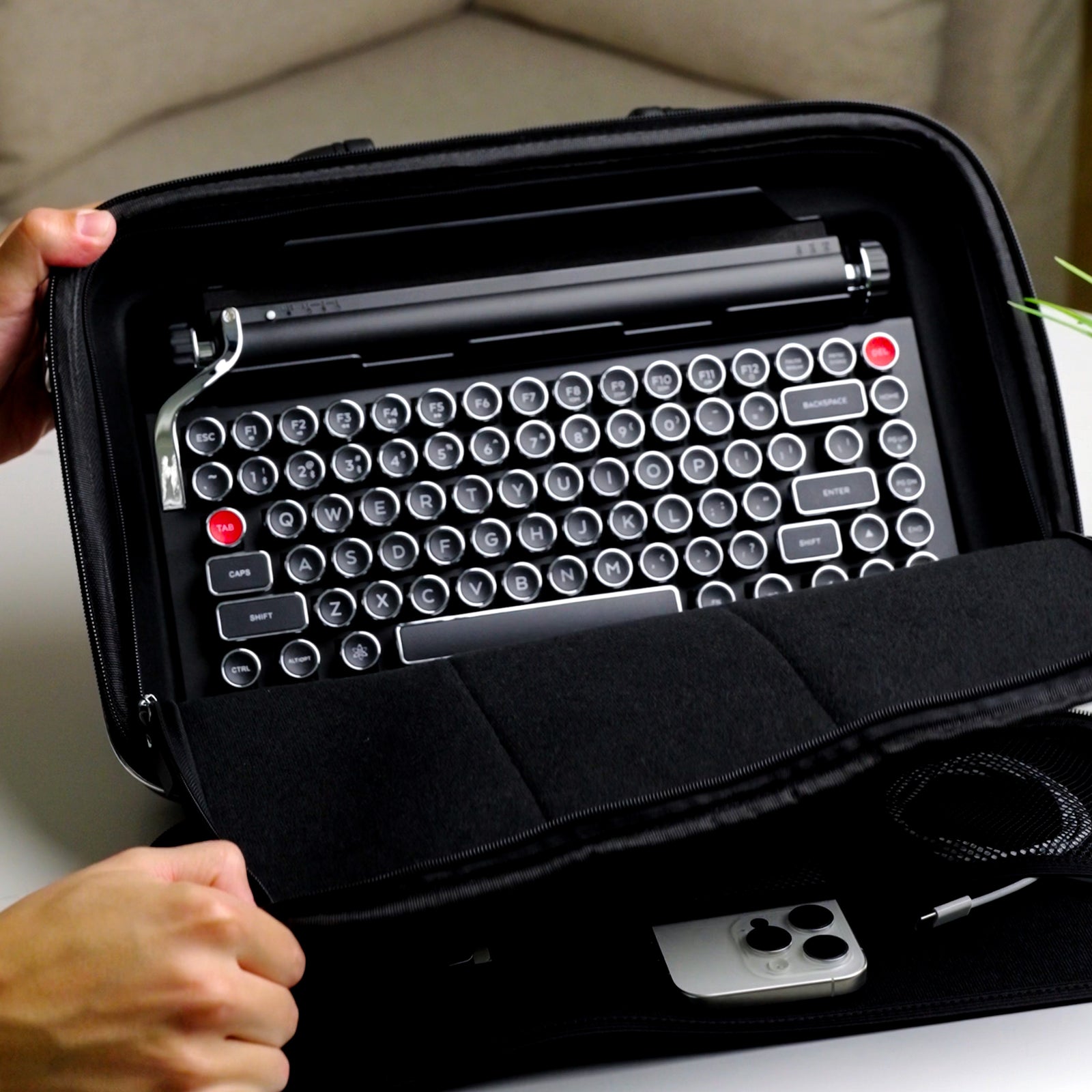 Black carrying case with compartments for electronic devices on a white background