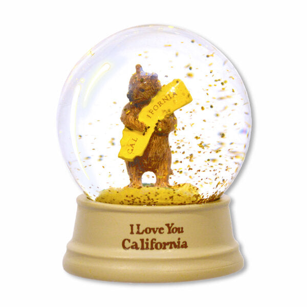 A clever twist to the traditional snow globe, this bear hug globe swirls gold dust when shaken. The bear hug design is inspired by vintage art from the 1913 sheet music cover of the California State Song, "I Love You California." Size: 2" wide x 2.5" high. Packaged in a kraft gift box.