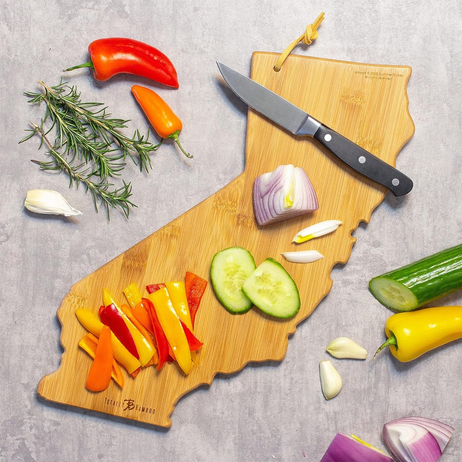 California-shaped cutting and charcuterie board with a colorful design featuring trees and flowers.