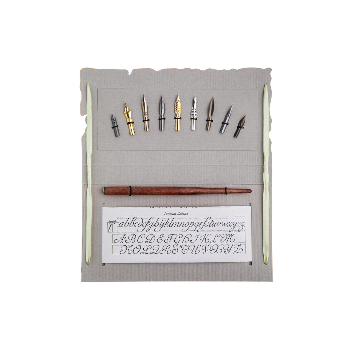 Set of calligraphy pens and nibs in a holder with a sample sheet on a white background