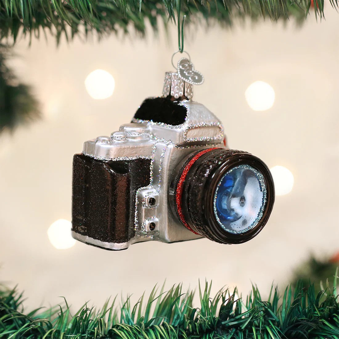 Camera-shaped glass holiday ornament on a white background