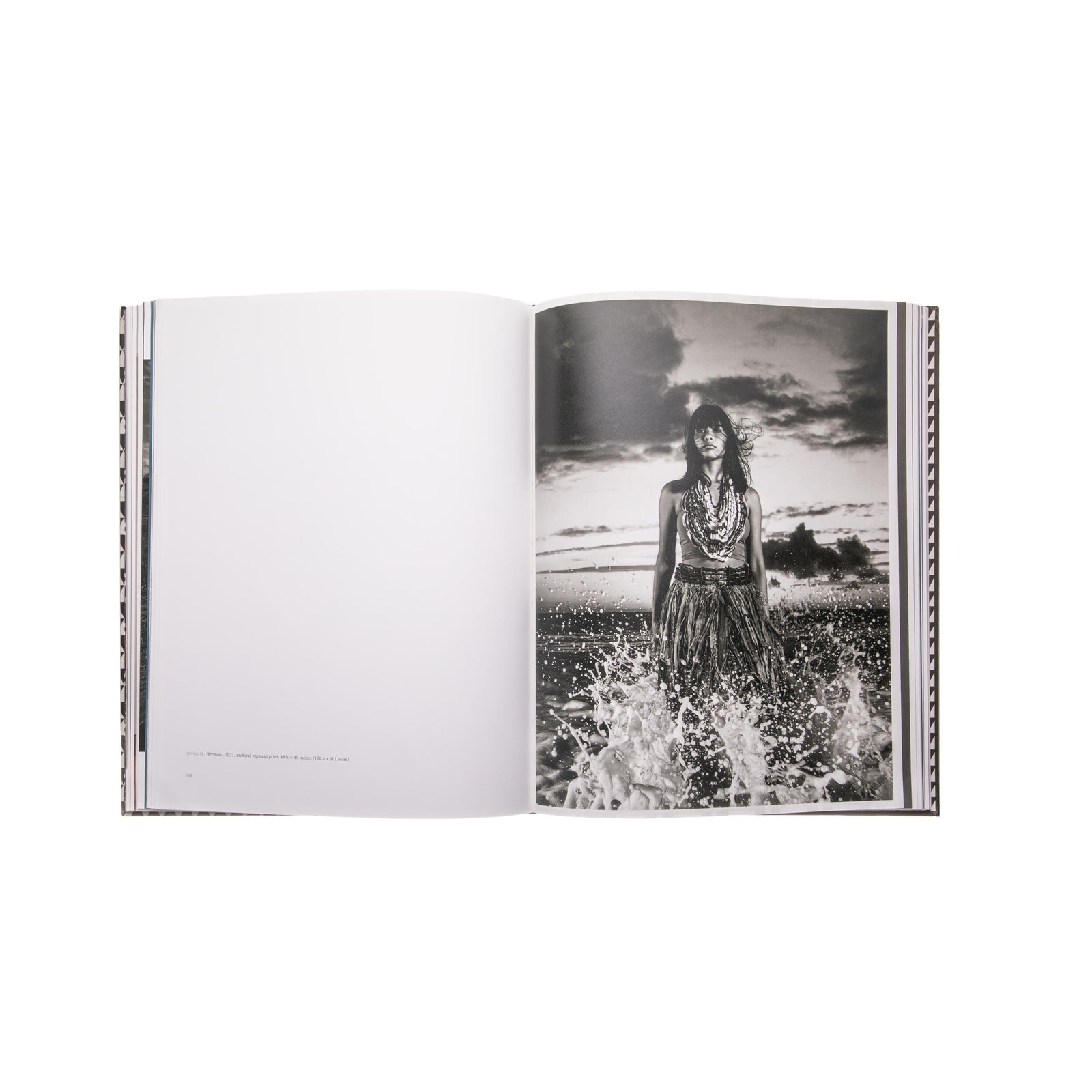 Book cover with a geometric pattern and a central image of a person in traditional attire on a red background by the artist Cara Romero. 