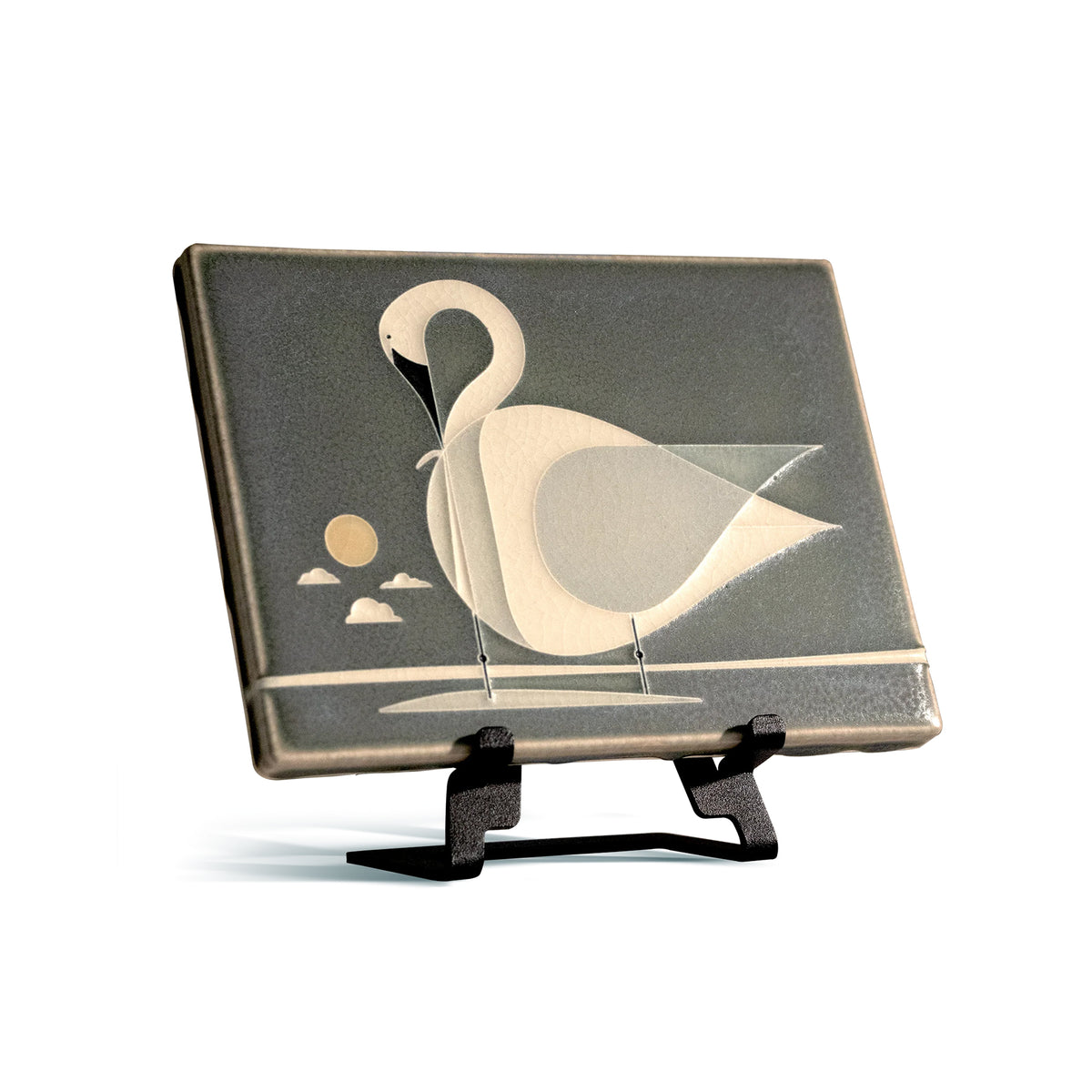 Decorative tile with a swan design on a stand against a white background