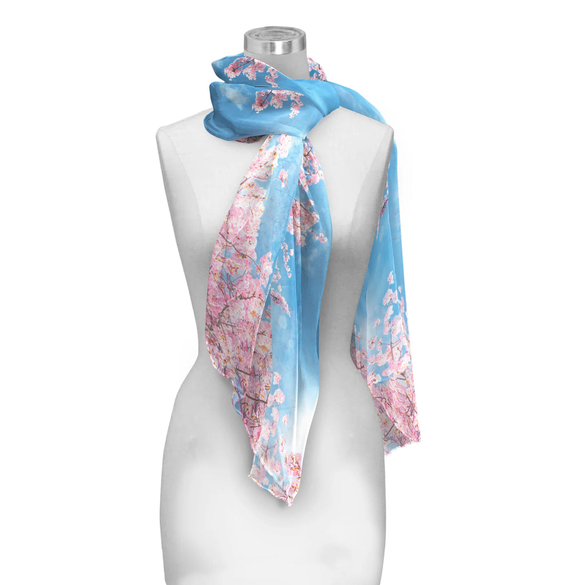 A lightweight blue scarf with a pink cherry blossom print draped on a white mannequin torso against a plain white background.