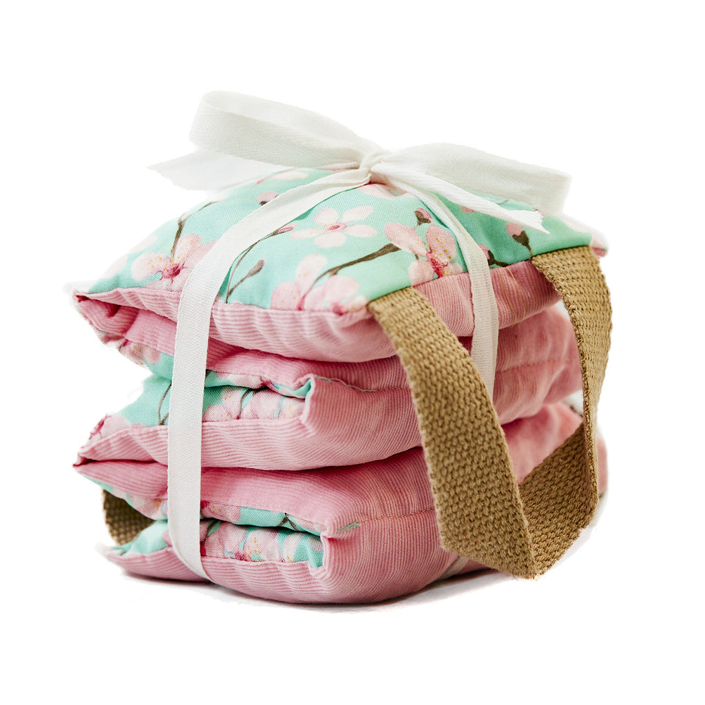 This therapeutic pillow is wrapped in a mint cherry blossom cotton fabric and backed with cozy pink corduroy. Suitable for hot and cold treatment anywhere on the body to release tension and soothe muscle aches. Filled with naturally cleaned cherry stones that are a by-product of domestic cherry farming. 5.5" x 20".