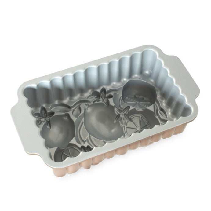 Decorative cake pan with fruit design on a white background