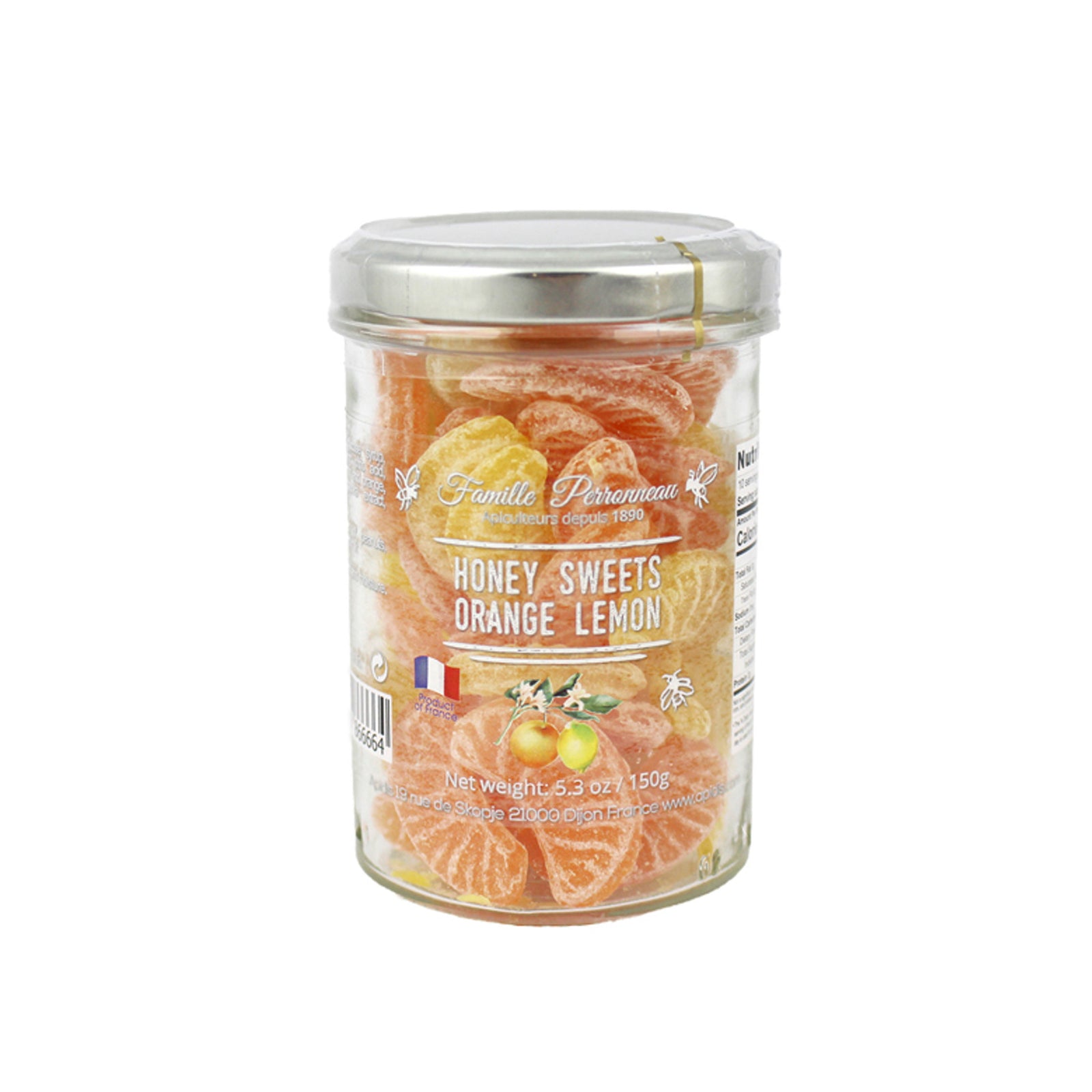 A glass jar of Famille Perrissonne Honey Sweets Orange Lemon, filled with orange and yellow citrus-flavored candies, topped with a silver metal lid, on a white background.