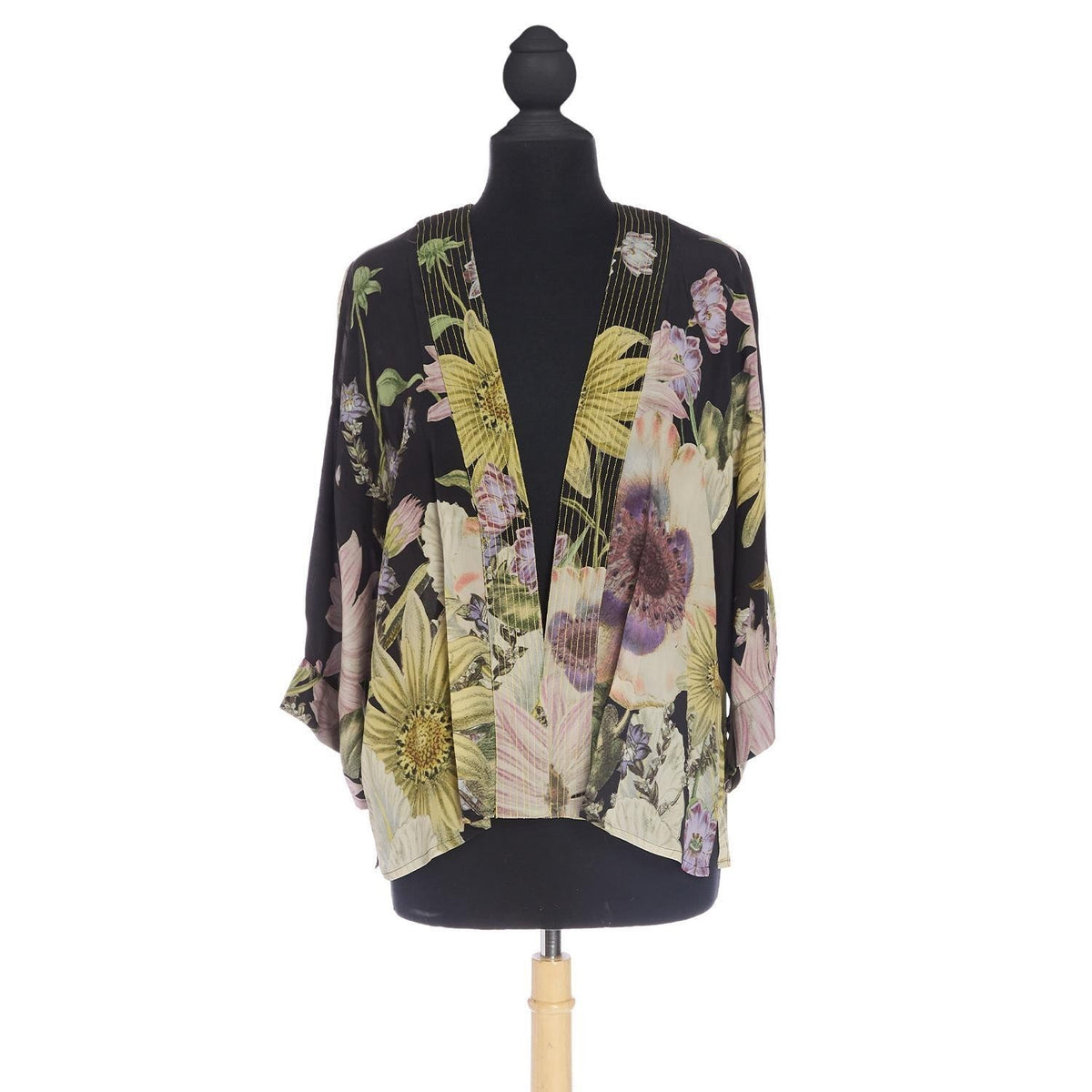 A short kimono style jacket with large daisy flowers printed on a black base. One size.