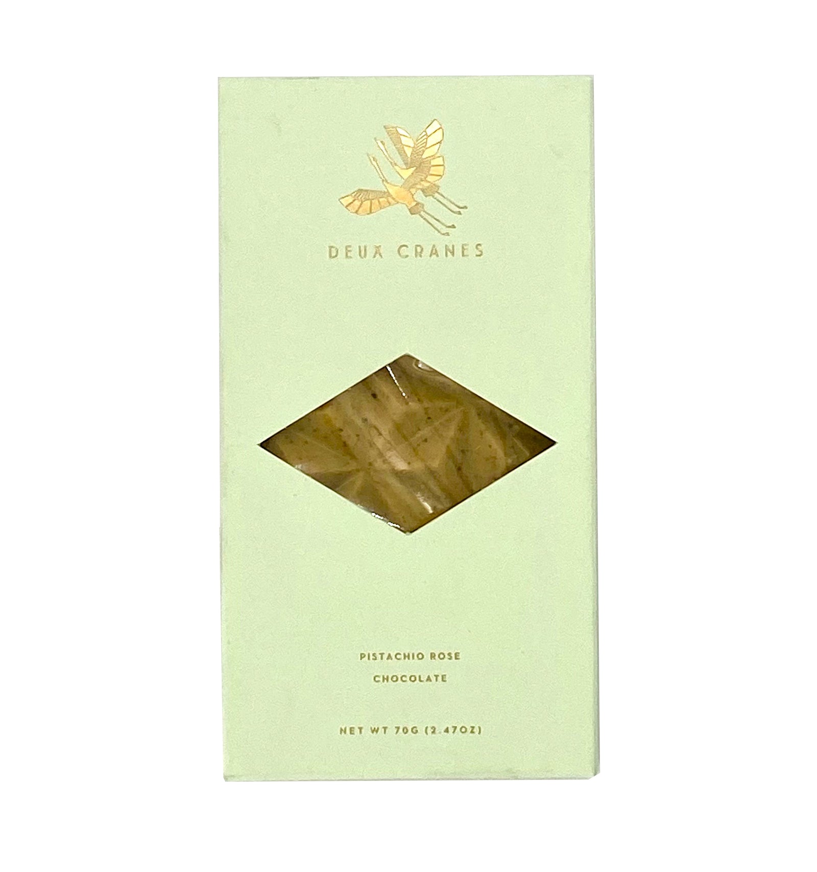 A packaged pistachio rose chocolate bar by Deux Cranes visible through a clear window, with green and gold design elements.