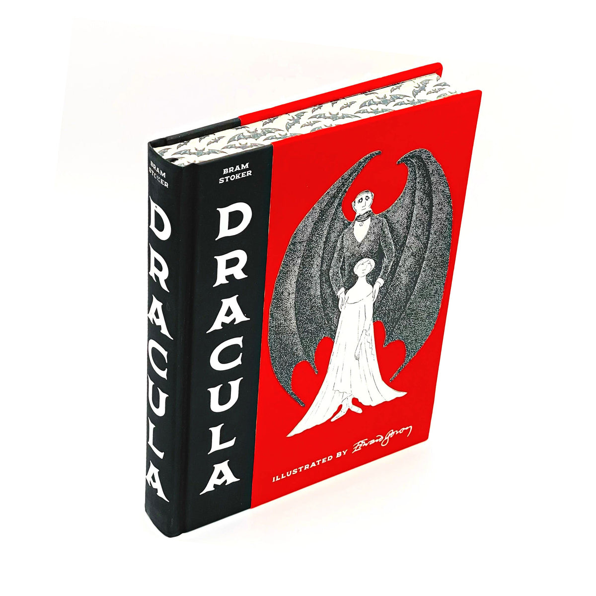 A collector's edition of the book 'Dracula' by Bram Stoker, featuring a red and black cover with an illustration of a figure in a white dress with a large, dark winged figure behind them.