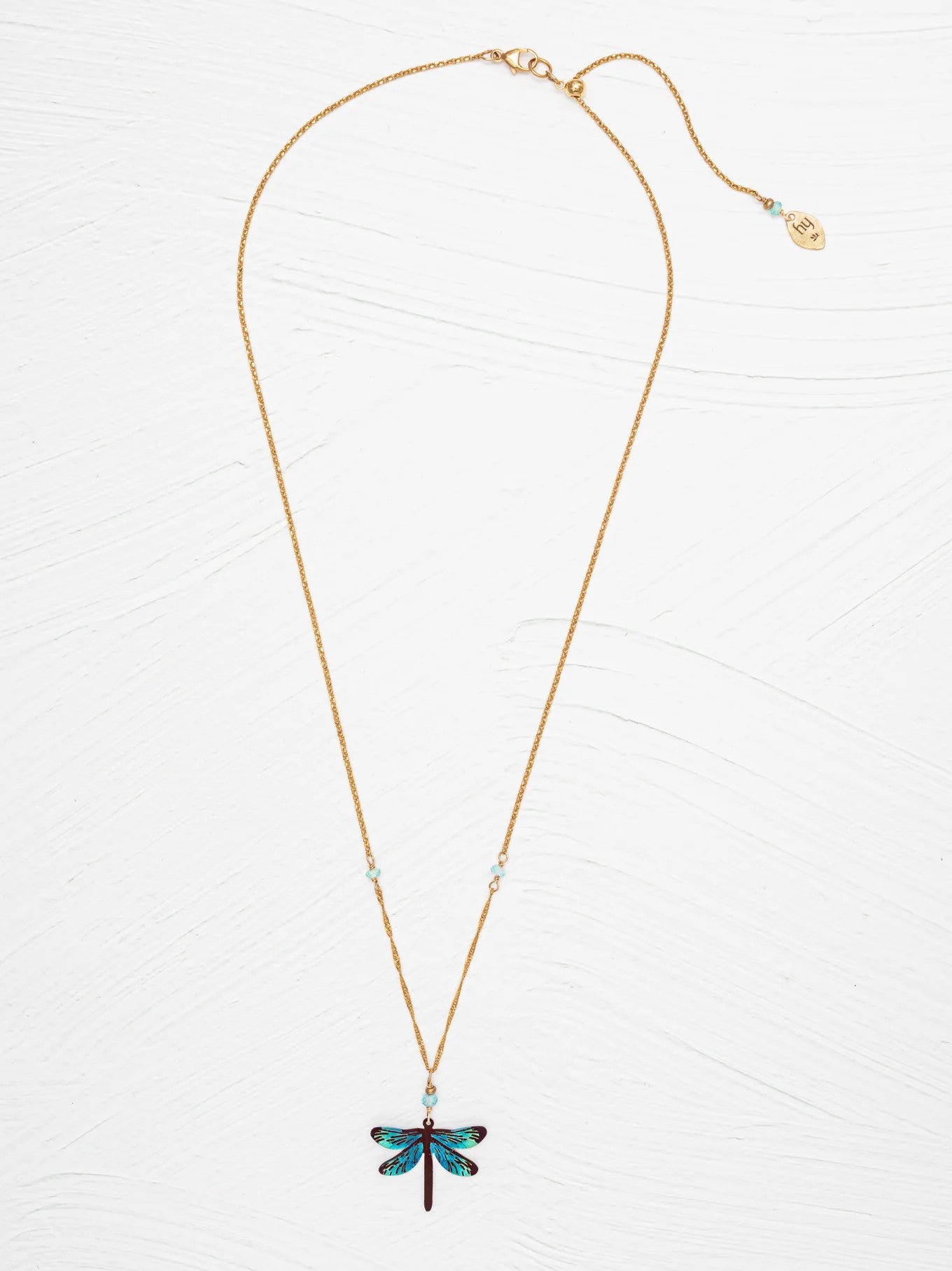 This colorful dragonfly necklace is artfully crafted with the most exquisite detailing: vibrant color, state-of-the-art metalwork, and careful hand linking and wiring. Materials: Niobium, apatite, 18k gold plated metal Dimensions: Adjustable 16-20"; 1 1/8" l. × 3/4" w. Pendant * Matching earrings available.