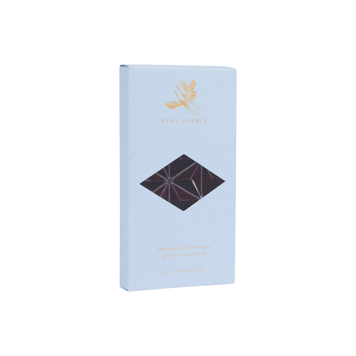 A light blue rectangular box of Deux Cranes Earl Grey dark chocolate, featuring a gold leaf logo and a diamond-shaped cutout window showing dark chocolate inside, set against a plain white background.