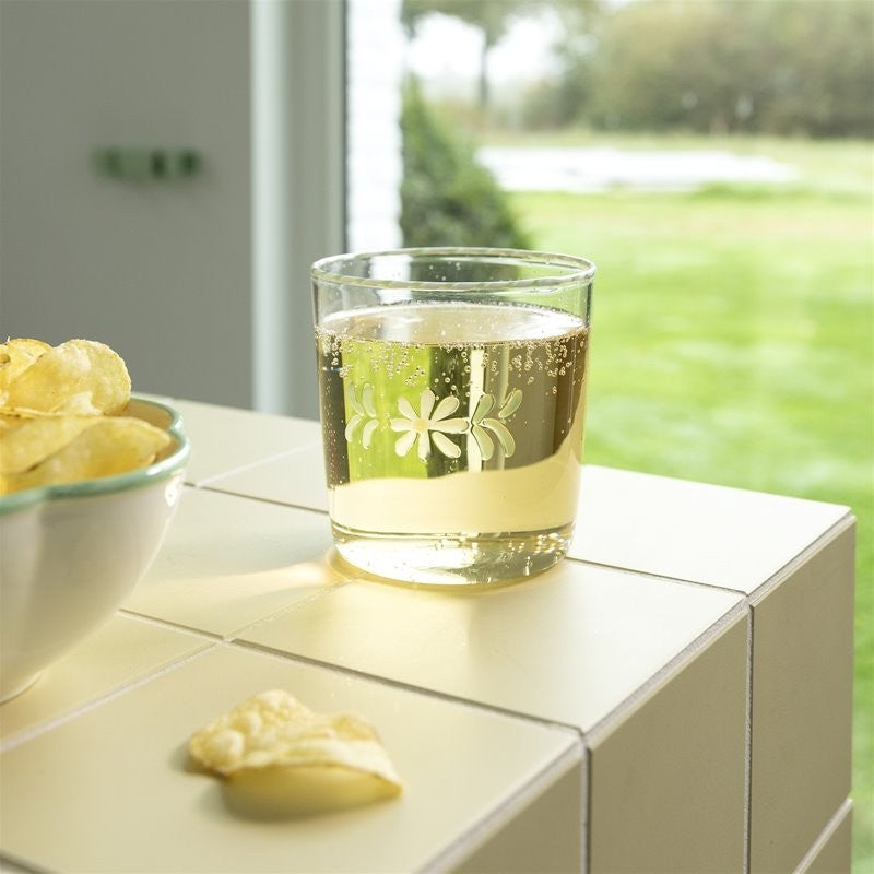 Glass of white wine with a floral design on a table outdoors