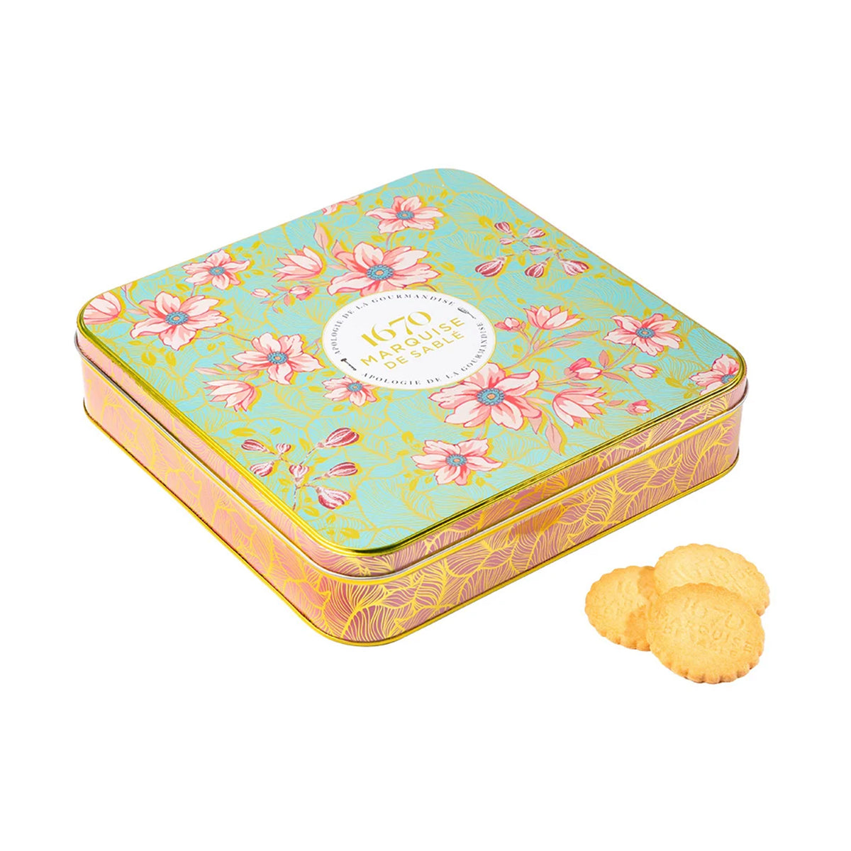 A square decorative tin box with a floral print on a mint green lid and pink-gold patterned sides, shown on a white background with three round golden biscuits beside it.