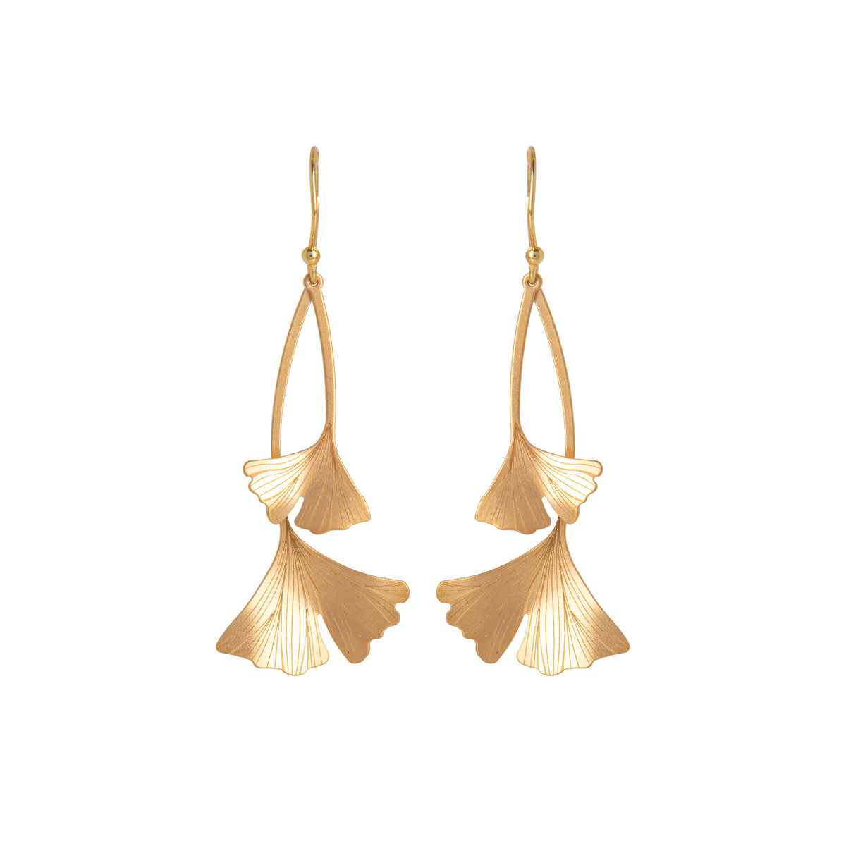 Pair of gold ginkgo leaf shaped earrings on a white background