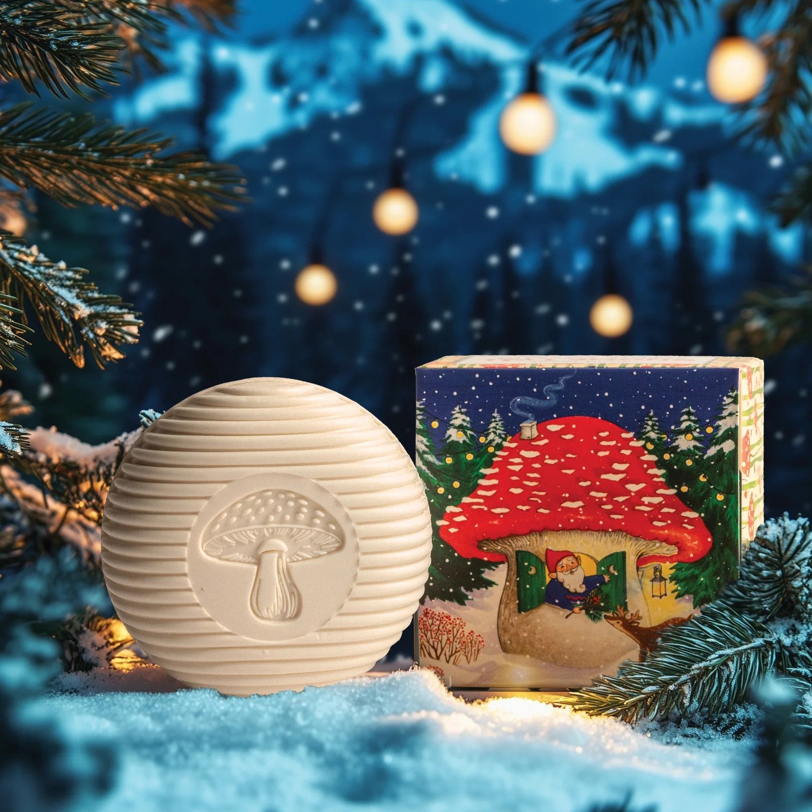 White mushroom-shaped bar soap with a colorful box featuring a Santa Claus gnome design on a white background