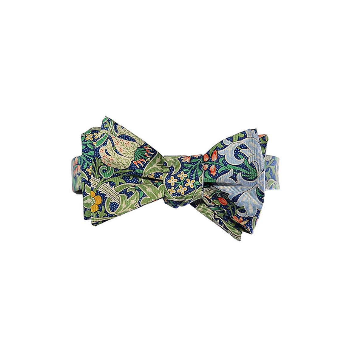 A pre-tied bow tie featuring a detailed paisley and floral pattern in shades of green, blue, orange, and white, William Morris Golden Lily design displayed against a solid white background.