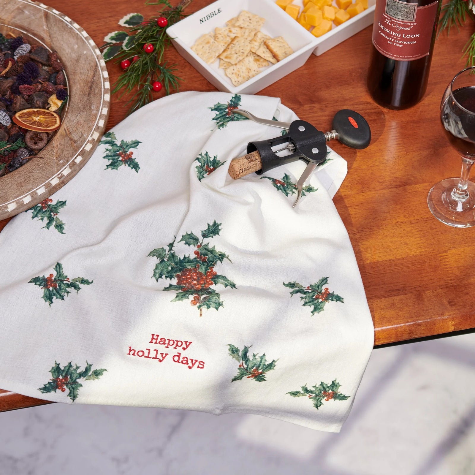 Decorative towel with holly design and 'Happy holly days' text on a white background