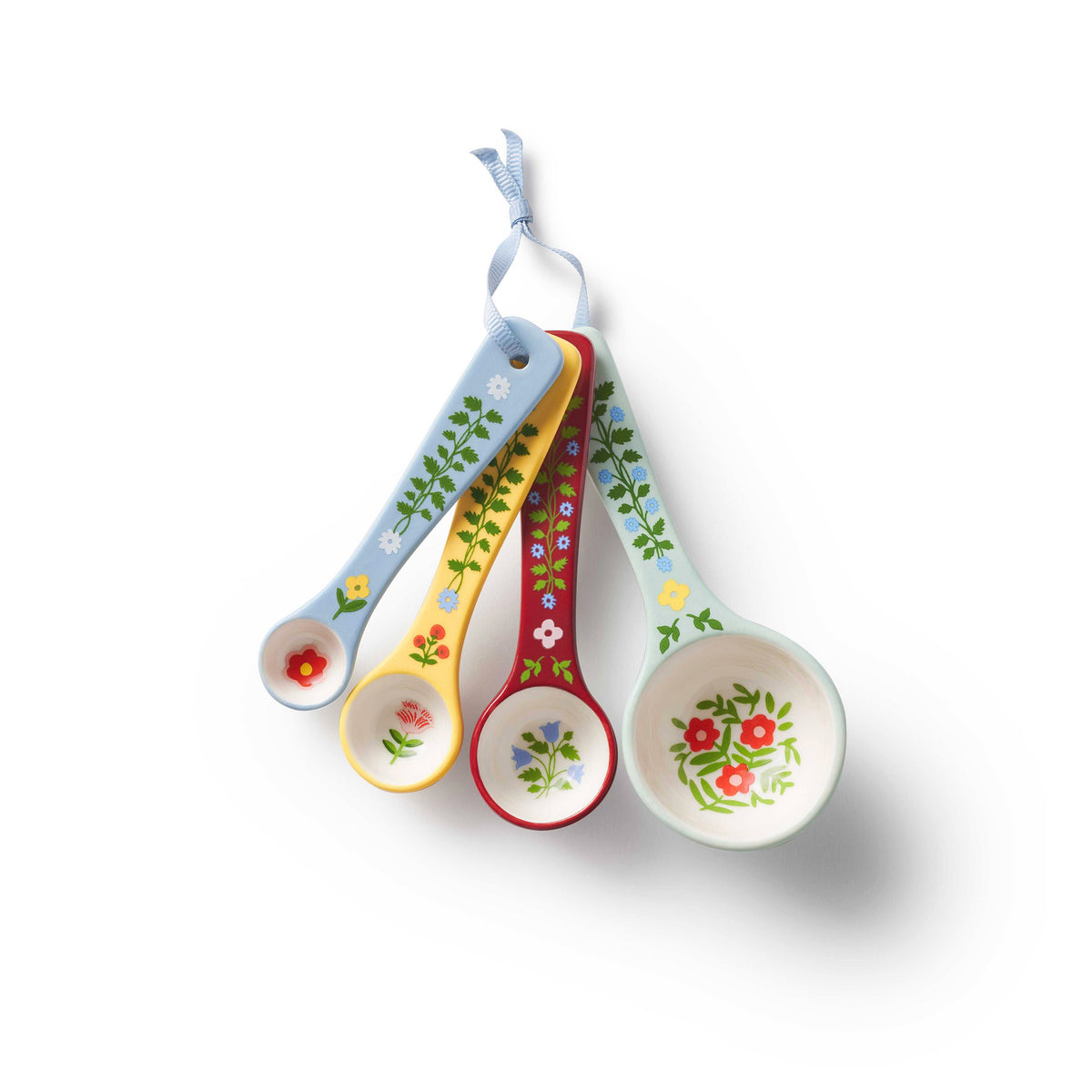 Set of four porcelain measuring spoons decorated with a folk-art style floral design on a white background. 