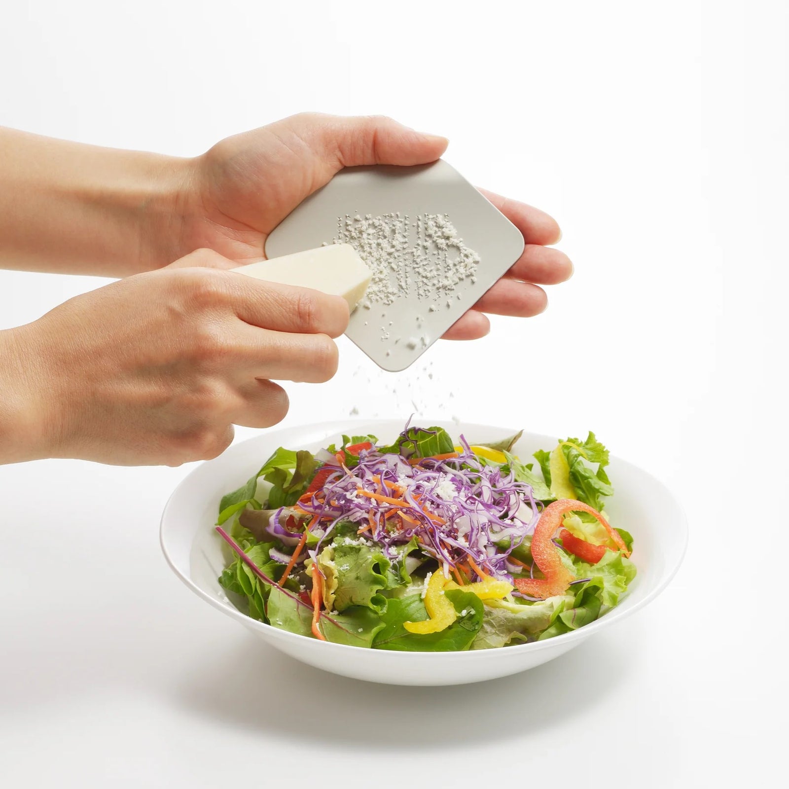 Green square grater with perforated design on a white background