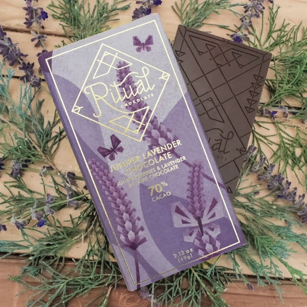 Lavender chocolate bar with packaging on a wooden surface with lavender flowers