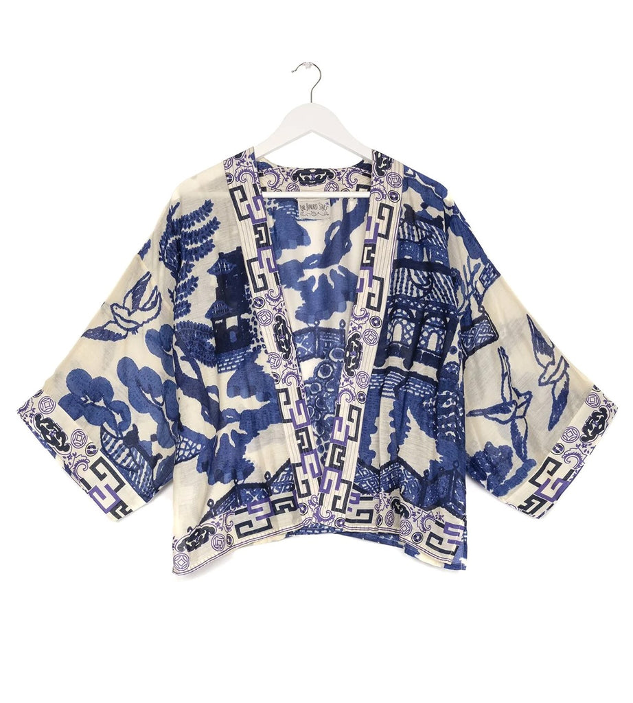 This striking short kimono jacket features the classic blue and white willow print which can often be found adorning vintage pottery. One Size Fits Most (US size 6-16). Nape to hem: 22". Chest: 52". Sleeve: 12" Sustainable Fabric. Ethically Sourced Product. 50% Modal 50% Cupro. Hand wash at 30ºc and cool iron only.